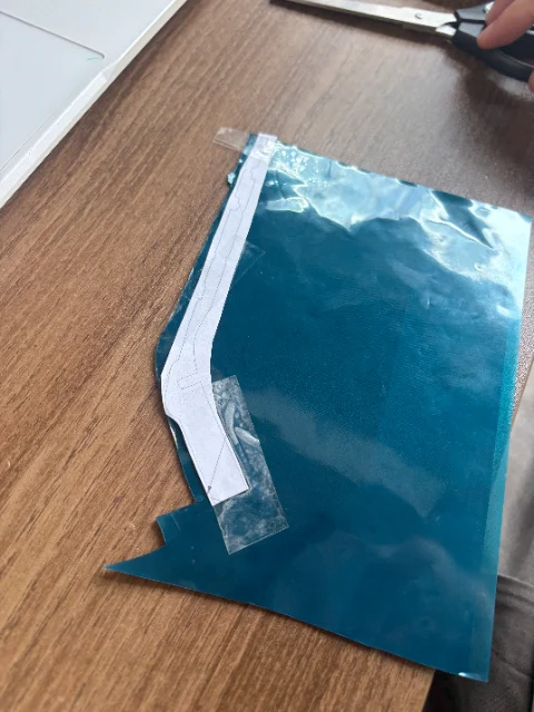 Paper temple pattern taped to sheet material during C100 thermal-management prototyping
